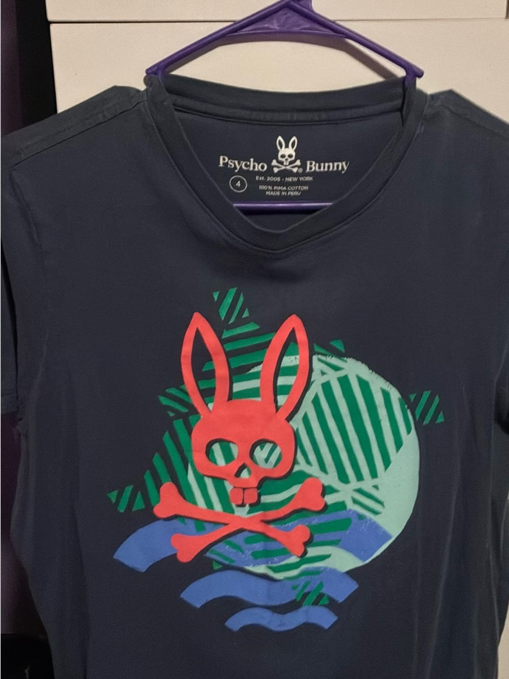 Psycho Bunny Navy Tee with Orange Bunny Skull Graphic and Teal Accents